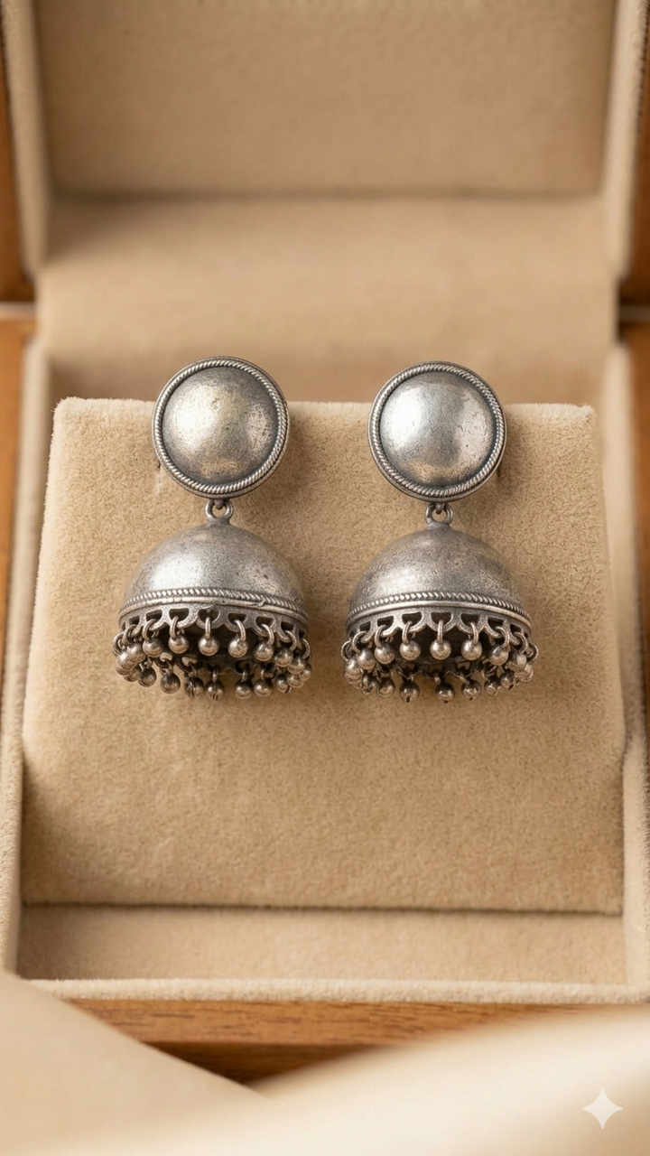 Oxidised silver-look statement earrings on a warm background