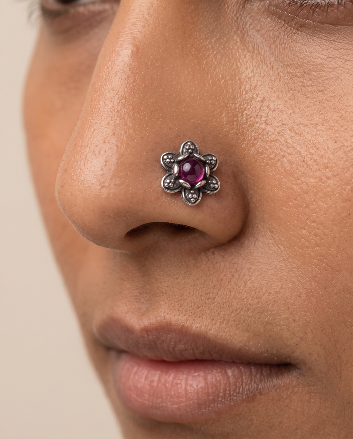 Divi floral nose pin with a purple stone worn on the nostril