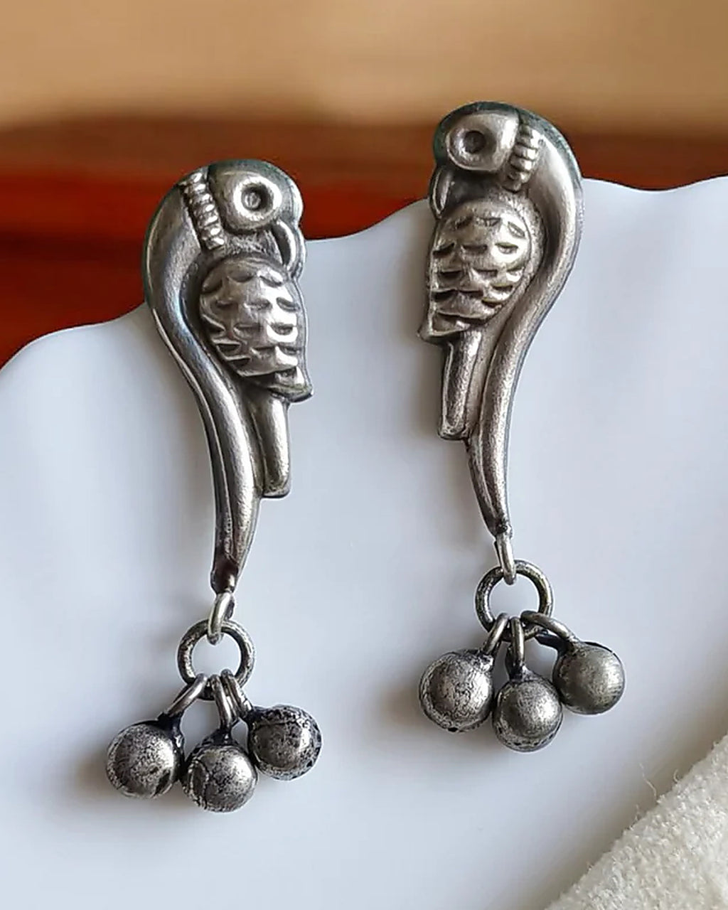 Oxidised silver-look brass drop earrings shaped as perched birds with clusters of small ghungroo bells
