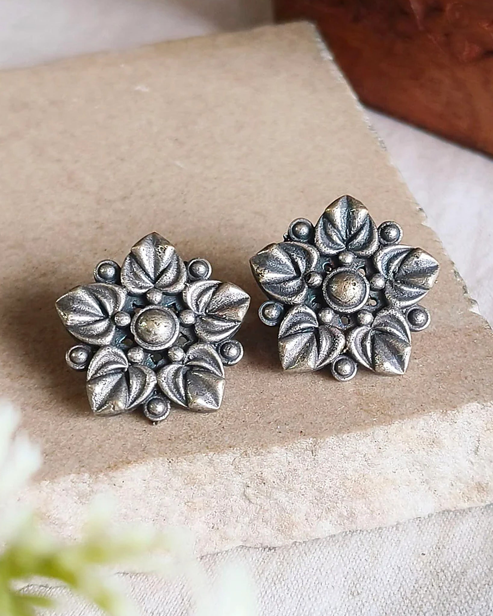 Oxidised silver-look brass stud earrings with layered flower petals edged in beadwork around a raised centre