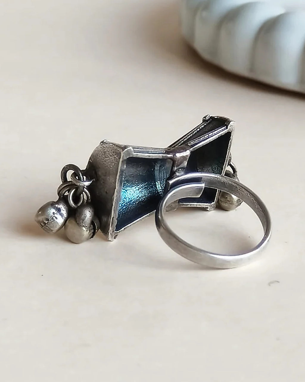 Oxidised silver-look brass statement ring shaped like a damru drum with small ghungroo bells at each end