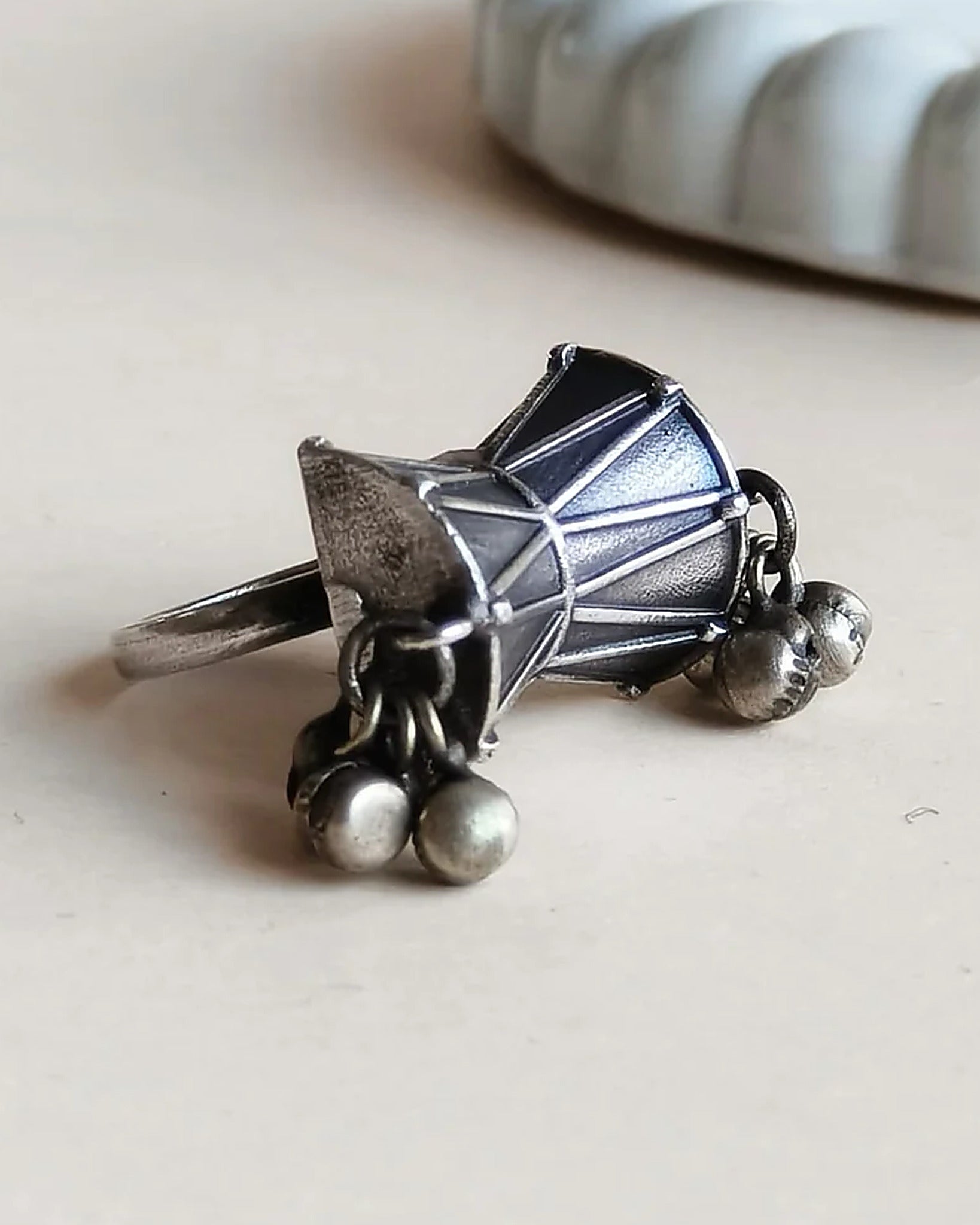 Oxidised silver-look brass statement ring shaped like a damru drum with small ghungroo bells at each end