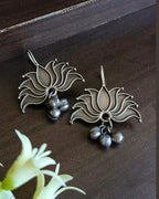 Oxidised silver-look brass drop earrings shaped as an open lotus with small ghungroo bells beneath