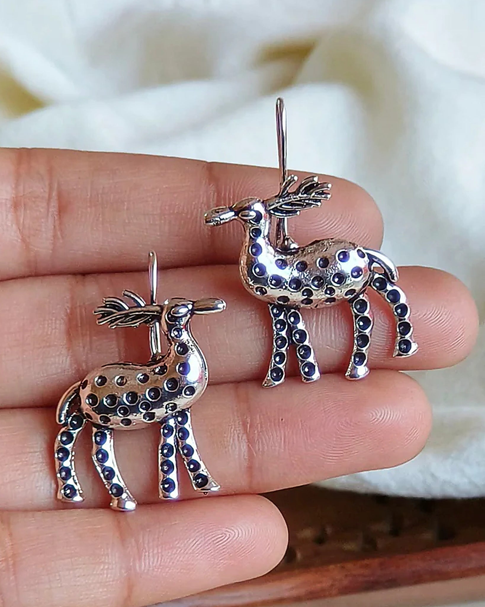 Oxidised silver-look brass drop earrings shaped as stags decorated with raised beadwork