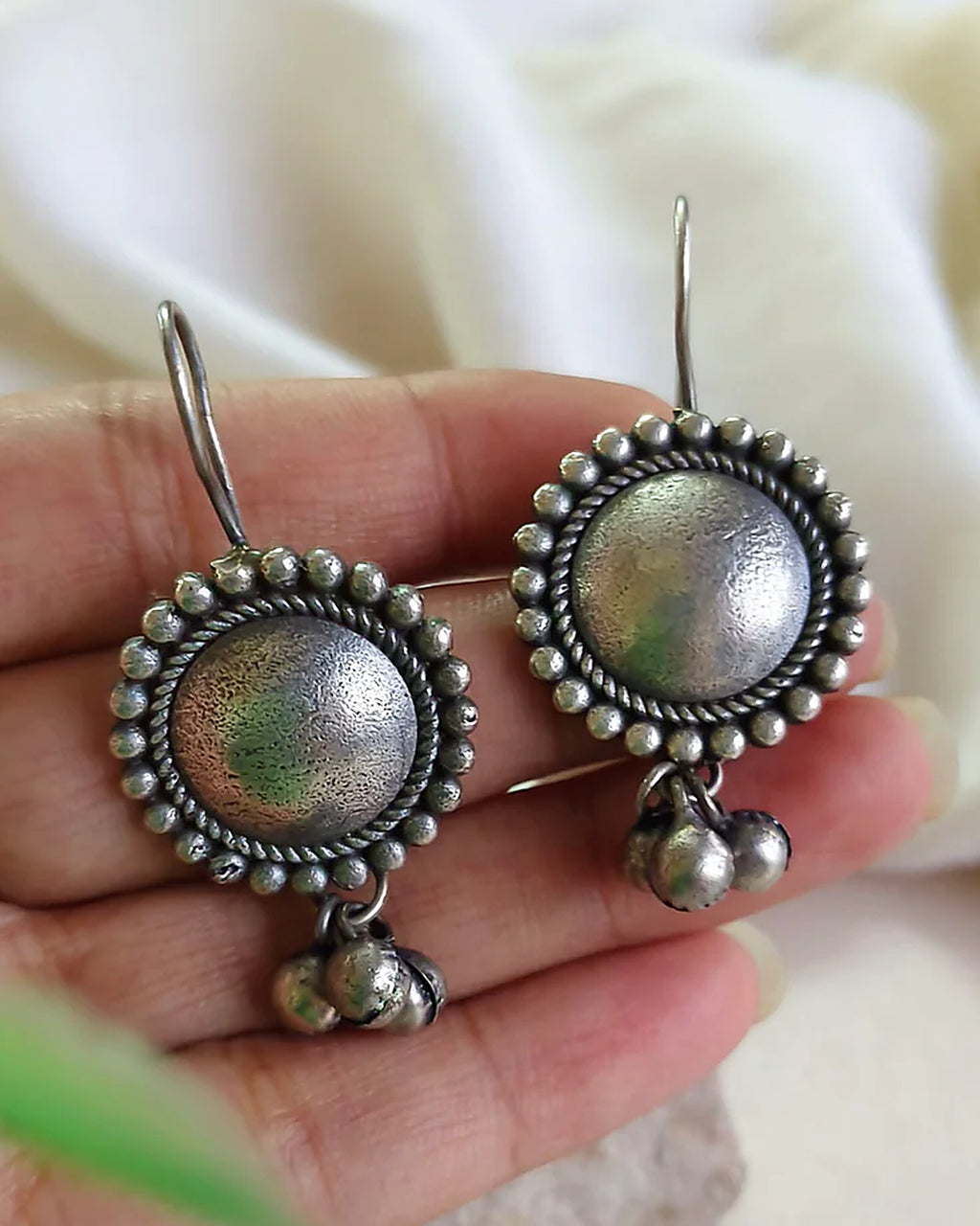 Oxidised silver-look brass drop earrings with a domed centre in a beaded halo and small ghungroo bells