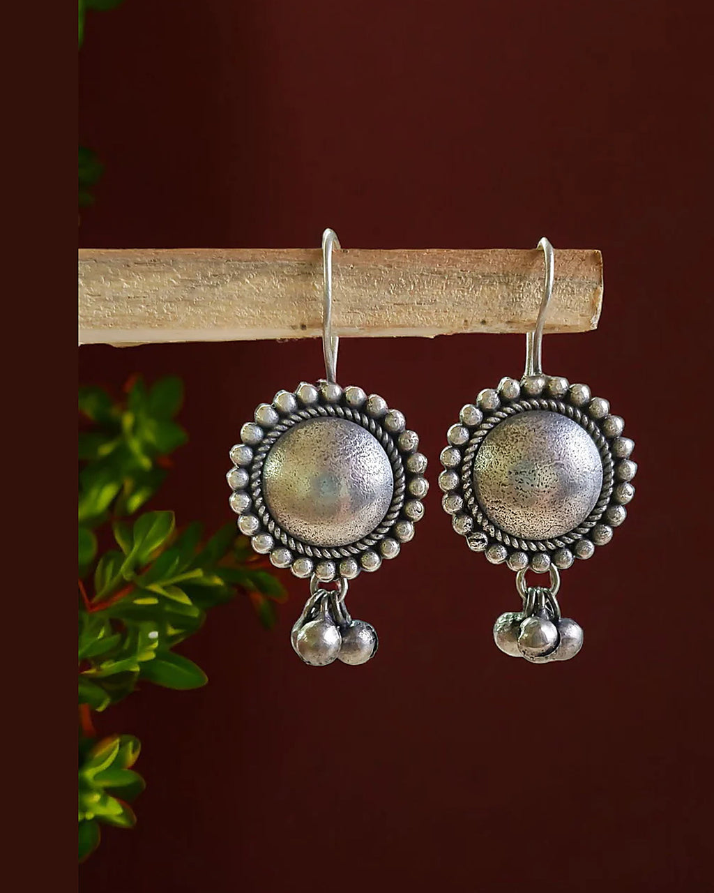 Oxidised silver-look brass drop earrings with a domed centre in a beaded halo and small ghungroo bells