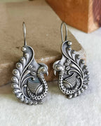 Oxidised silver-look brass drop earrings shaped as a peacock with a spiralled tail