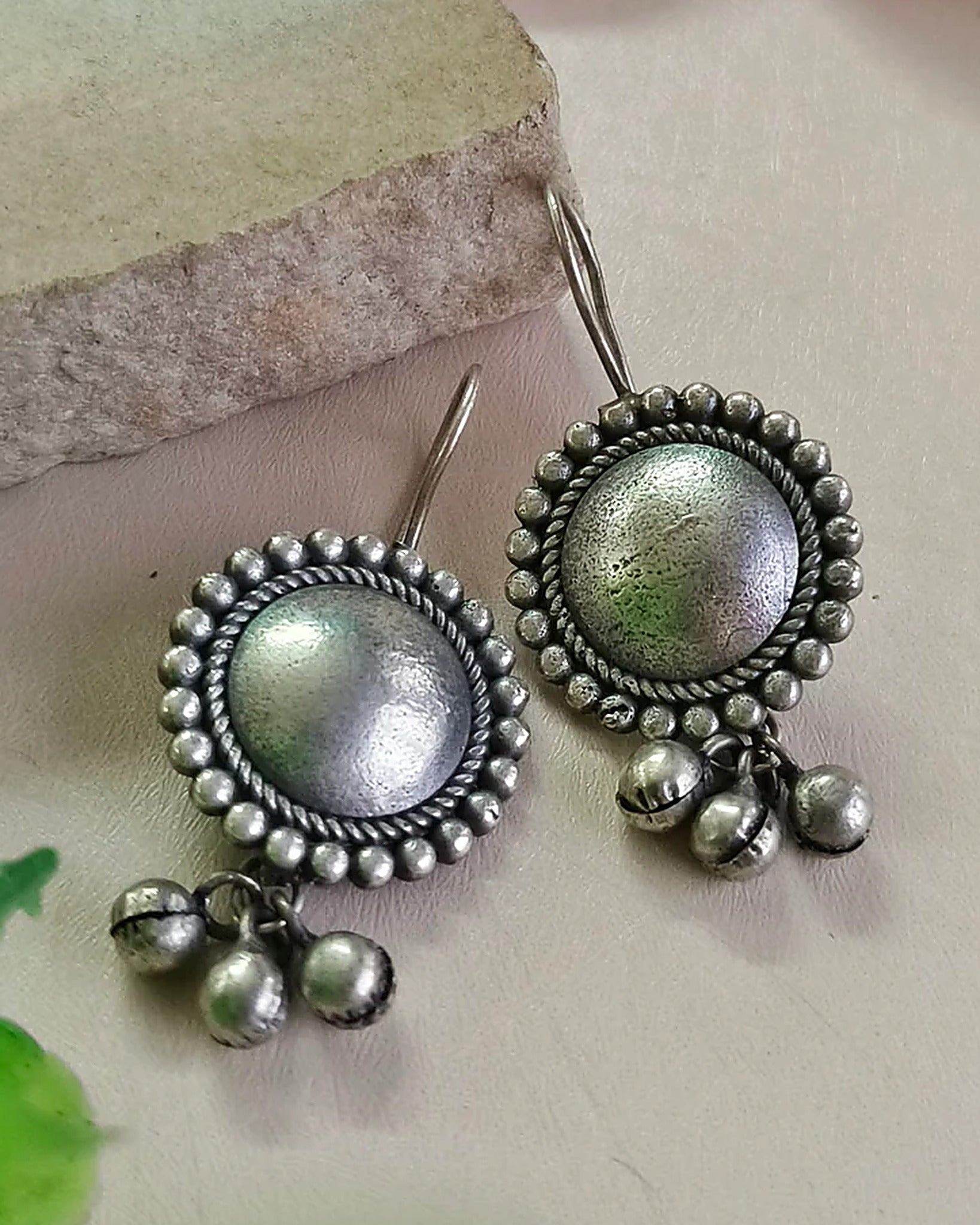 Oxidised silver-look brass drop earrings with a domed centre in a beaded halo and small ghungroo bells