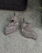 Oxidised silver-look brass drop earrings shaped as a peacock in fine open filigree work