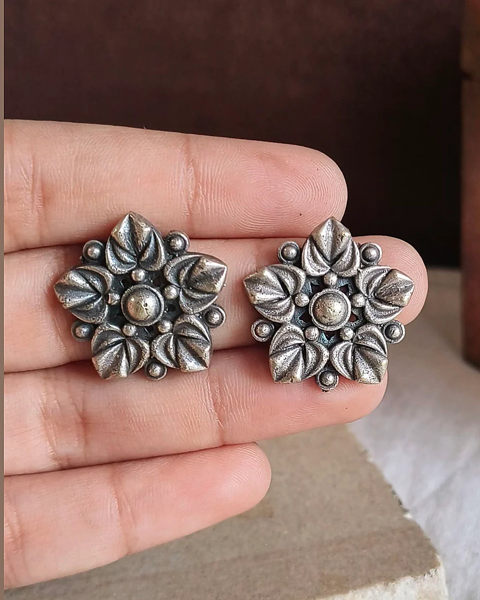 Oxidised silver-look brass stud earrings with layered flower petals edged in beadwork around a raised centre