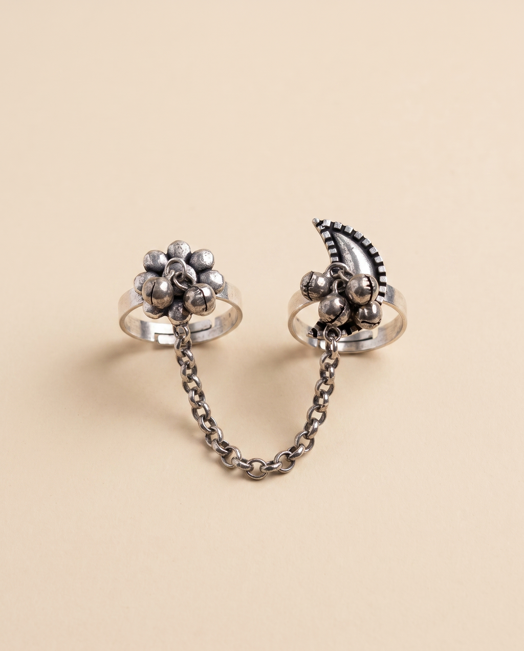 Pushkara oxidised silver-look two-finger ring — a beaded floral cluster and a crescent motif with ghungroo bells, joined by a silver chain