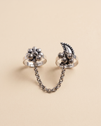 Pushkara oxidised silver-look two-finger ring — a beaded floral cluster and a crescent motif with ghungroo bells, joined by a silver chain