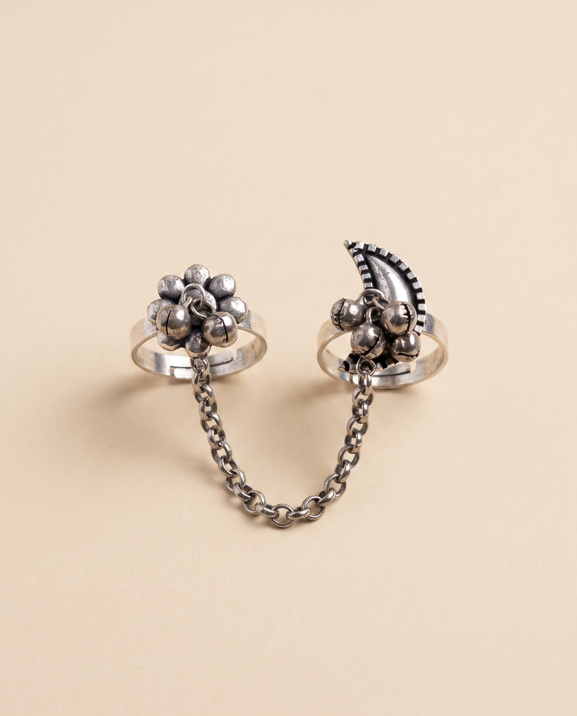 Pushkara oxidised silver-look two-finger ring — a beaded floral cluster and a crescent motif with ghungroo bells, joined by a silver chain
