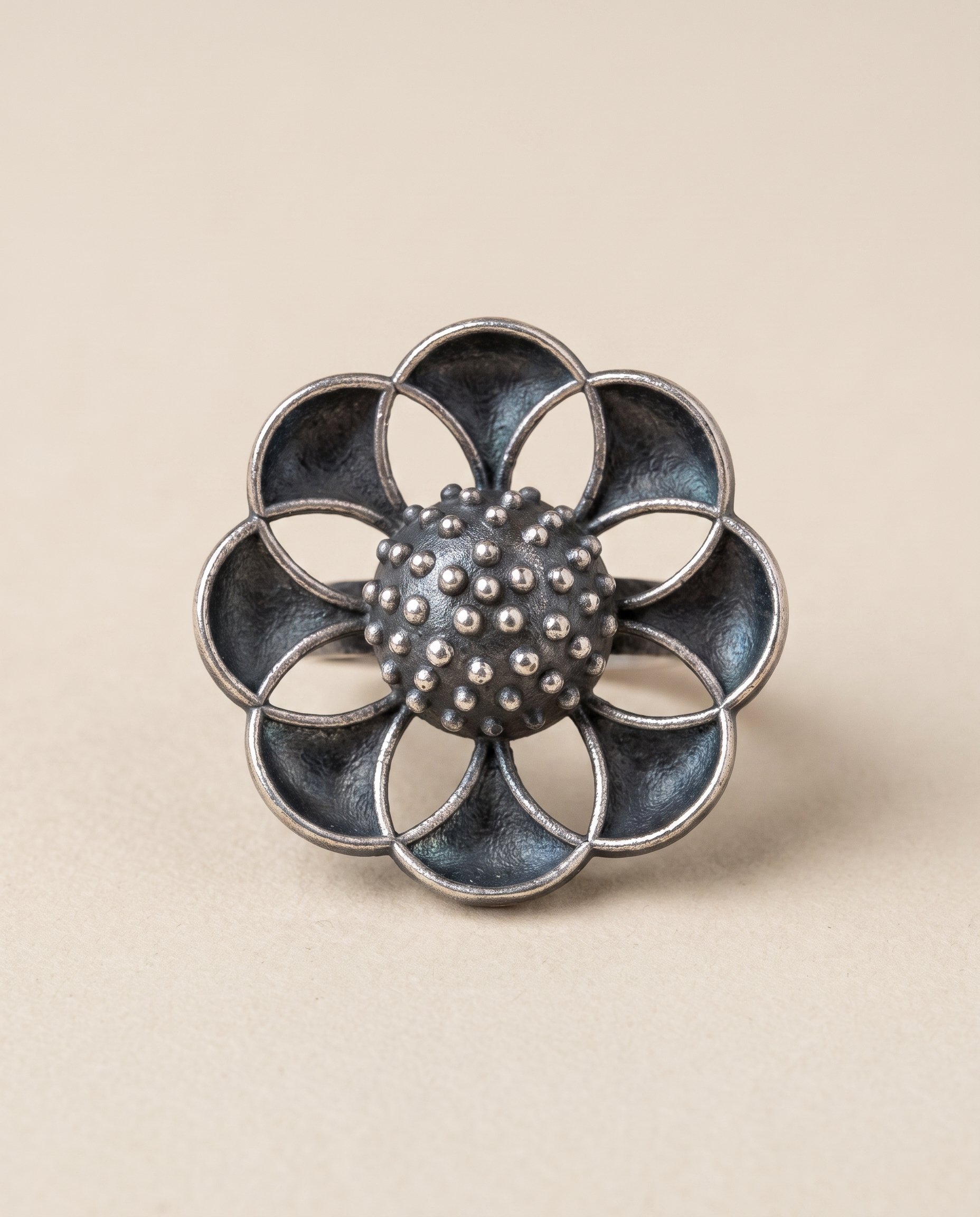 Vibha oxidised silver-look statement ring — eight overlapping petals arranged around a granulated centre dome
