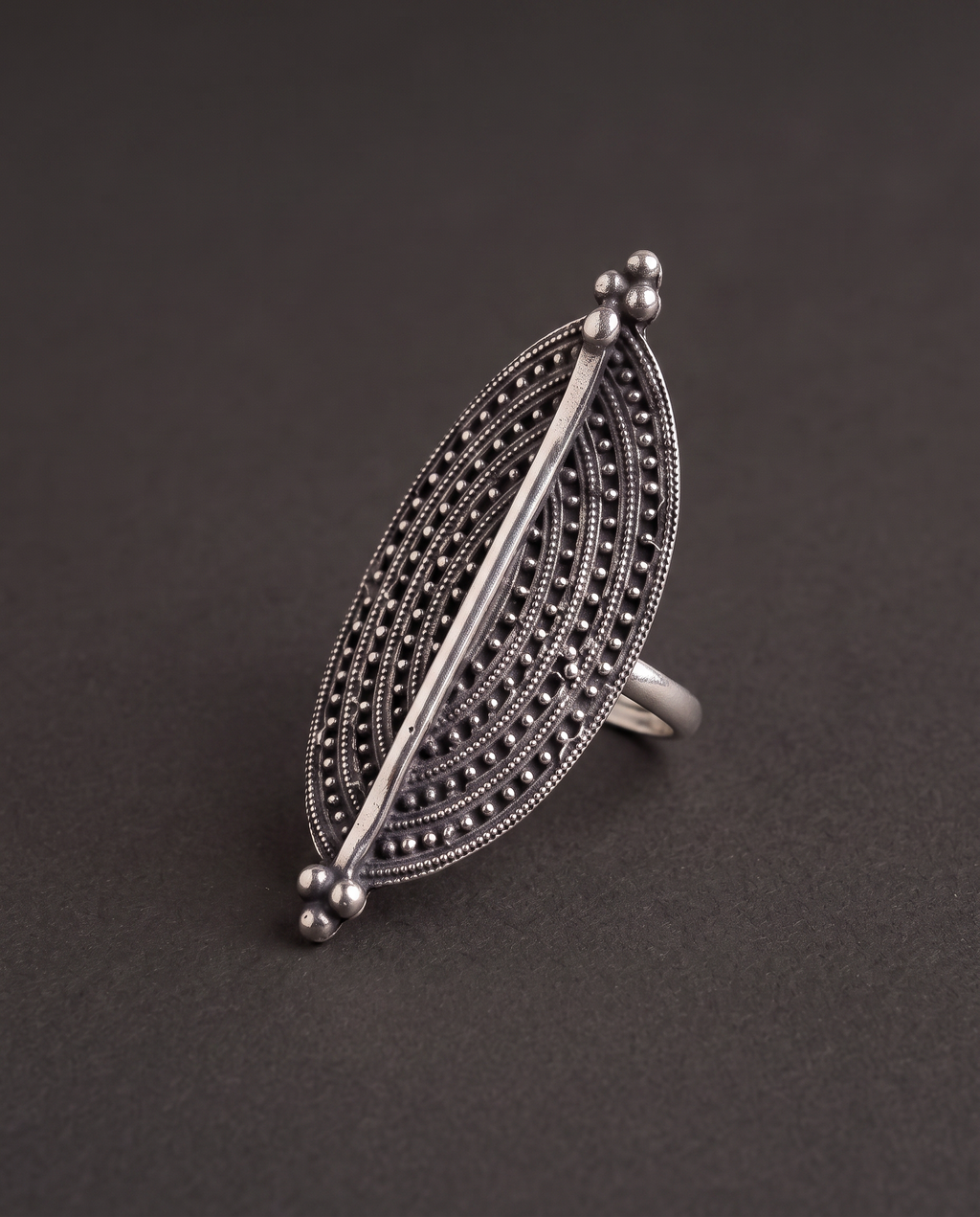 Close-up of the Virushka marquise ring on charcoal, showing the rows of fine granulation and the bright polished centre spine