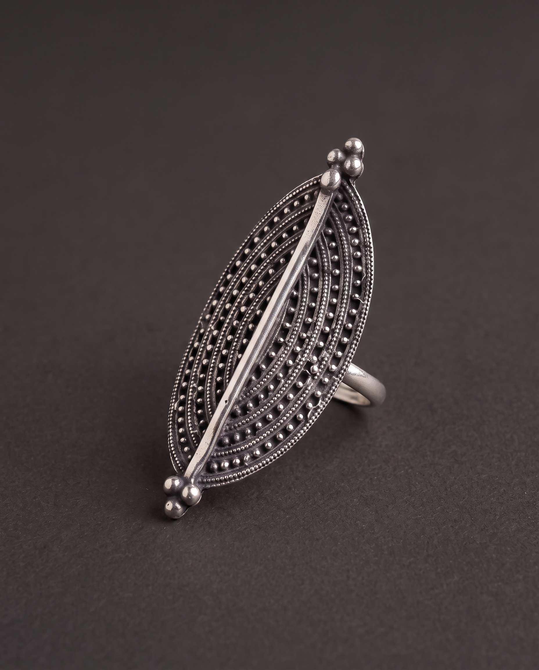 Close-up of the Virushka marquise ring on charcoal, showing the rows of fine granulation and the bright polished centre spine