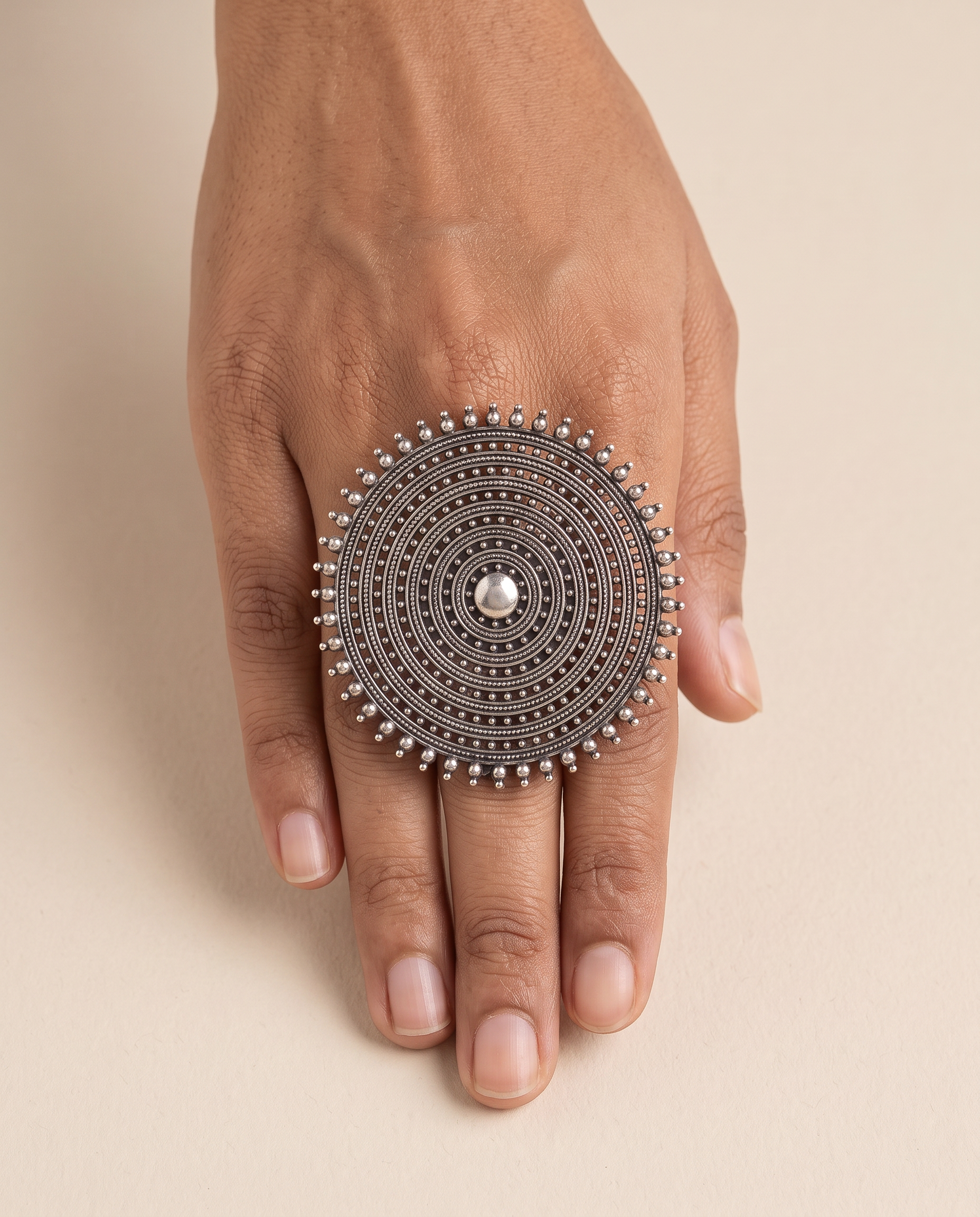Nishan concentric disc statement ring worn on the middle finger, showing how large it sits on the hand