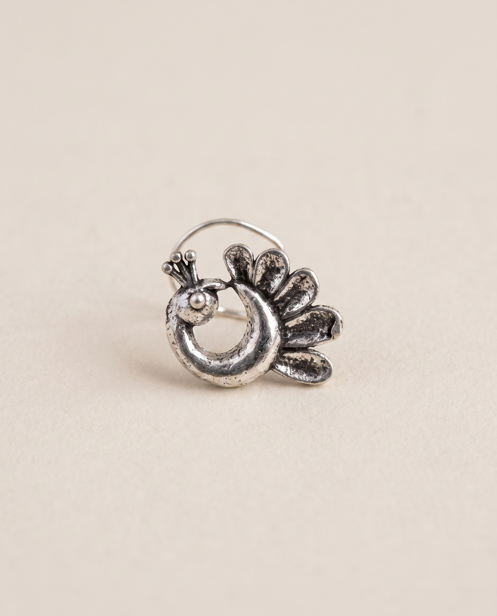 Morni oxidised silver-look peacock piercing nose pin with a fanned petal tail and beaded crest