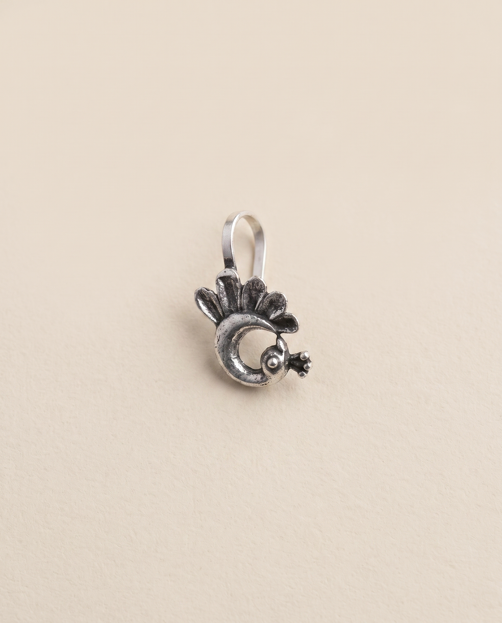 Morni oxidised silver-look peacock clip-on nose pin with a fanned tail and crested head