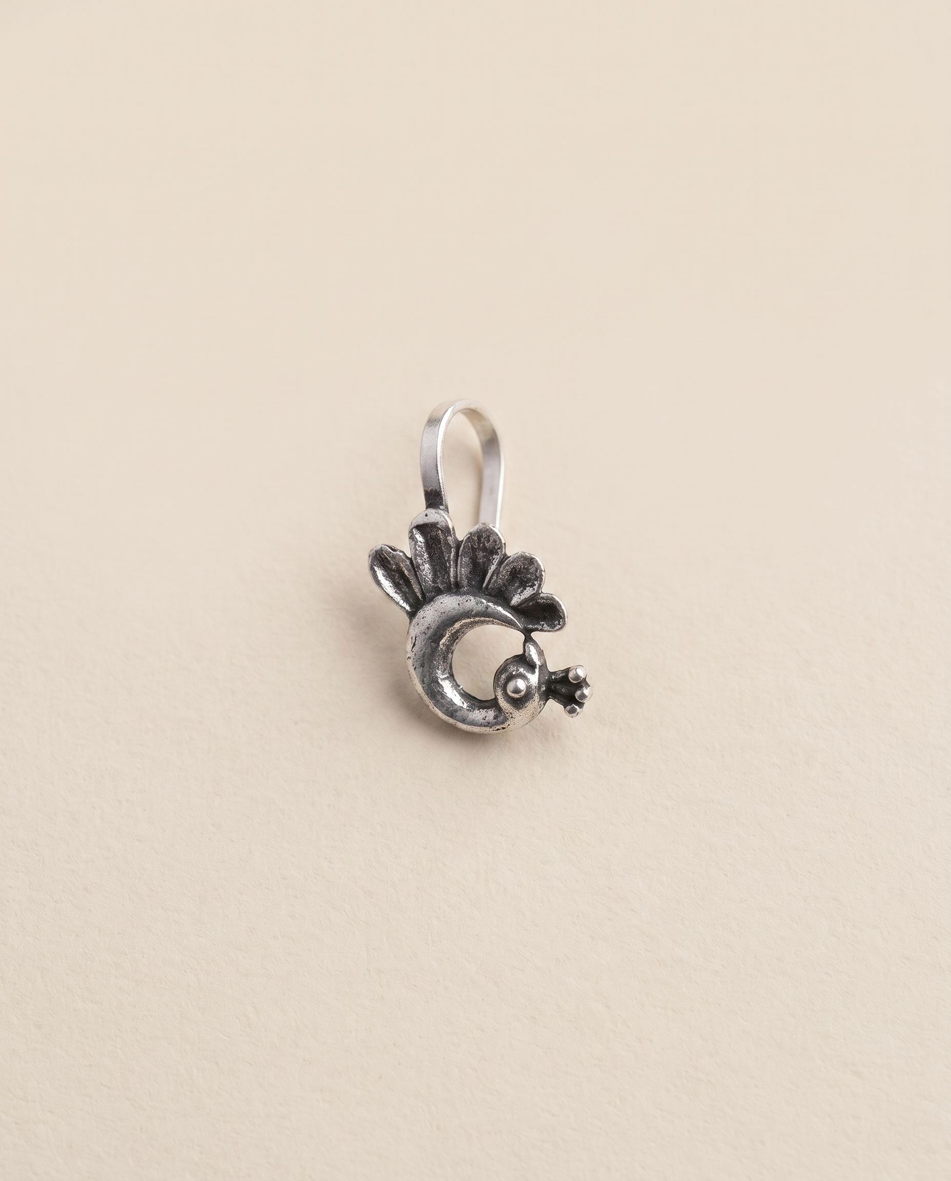 Morni oxidised silver-look peacock clip-on nose pin with a fanned tail and crested head