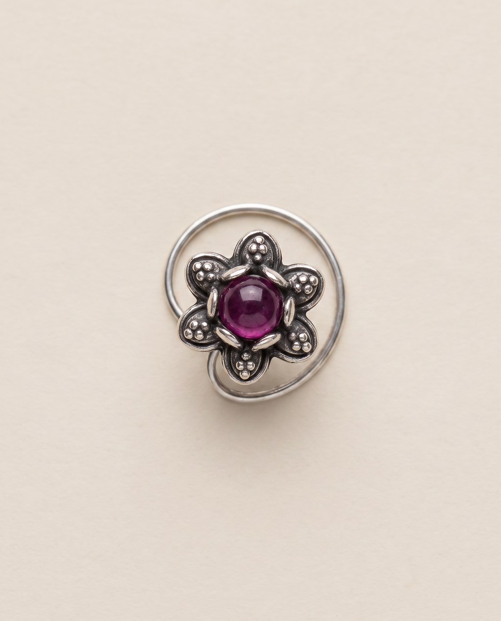 Divi oxidised silver-look floral nose pin with a deep magenta-purple centre stone and a curved wire fitting