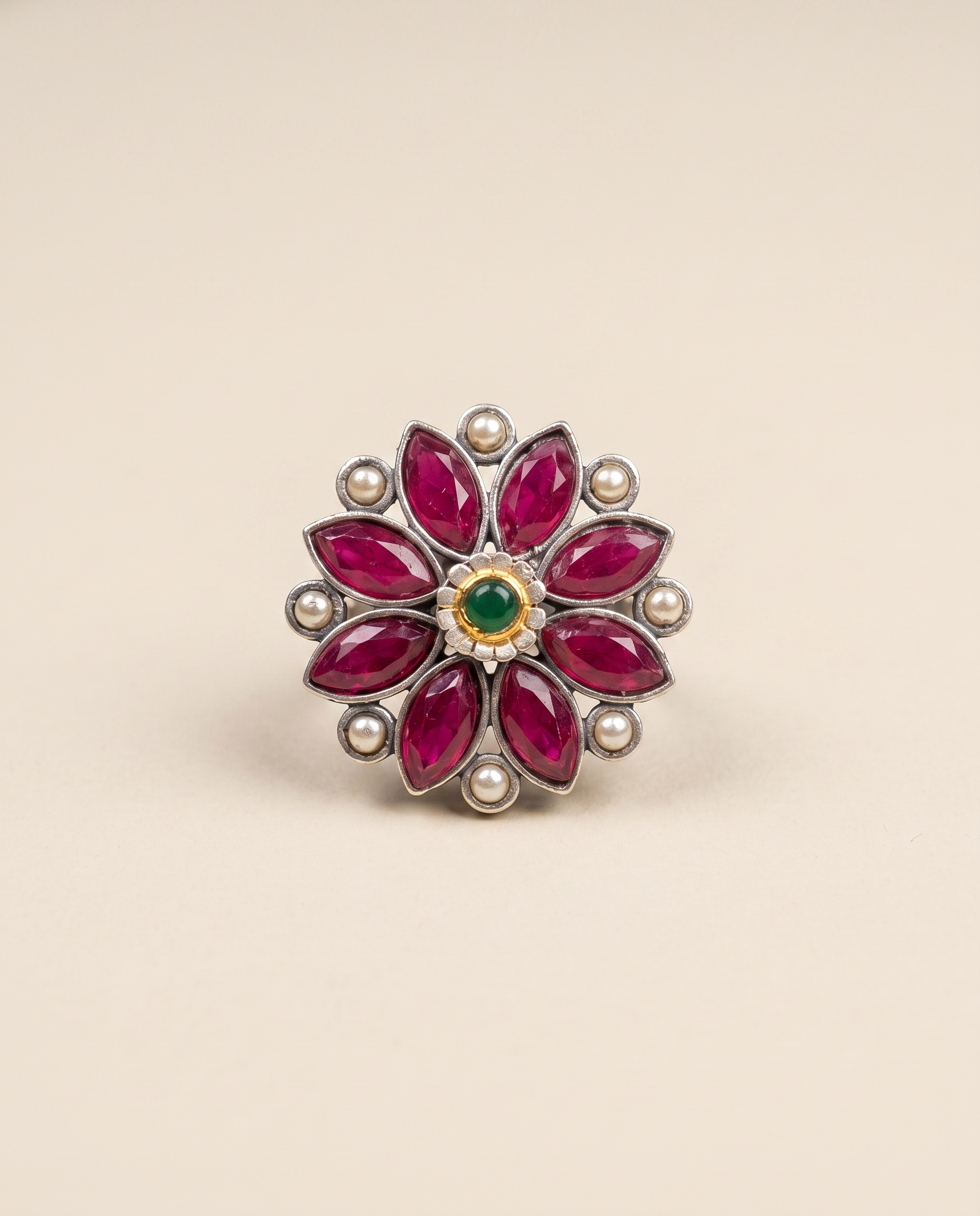 Anant oxidised silver-look flower ring with ruby-magenta marquise stones, cream pearls and a green centre stone in a gold bezel