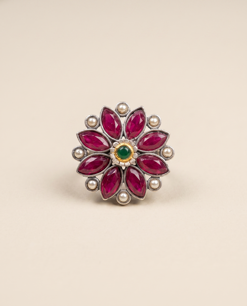 Anant oxidised silver-look flower ring with ruby-magenta marquise stones, cream pearls and a green centre stone in a gold bezel
