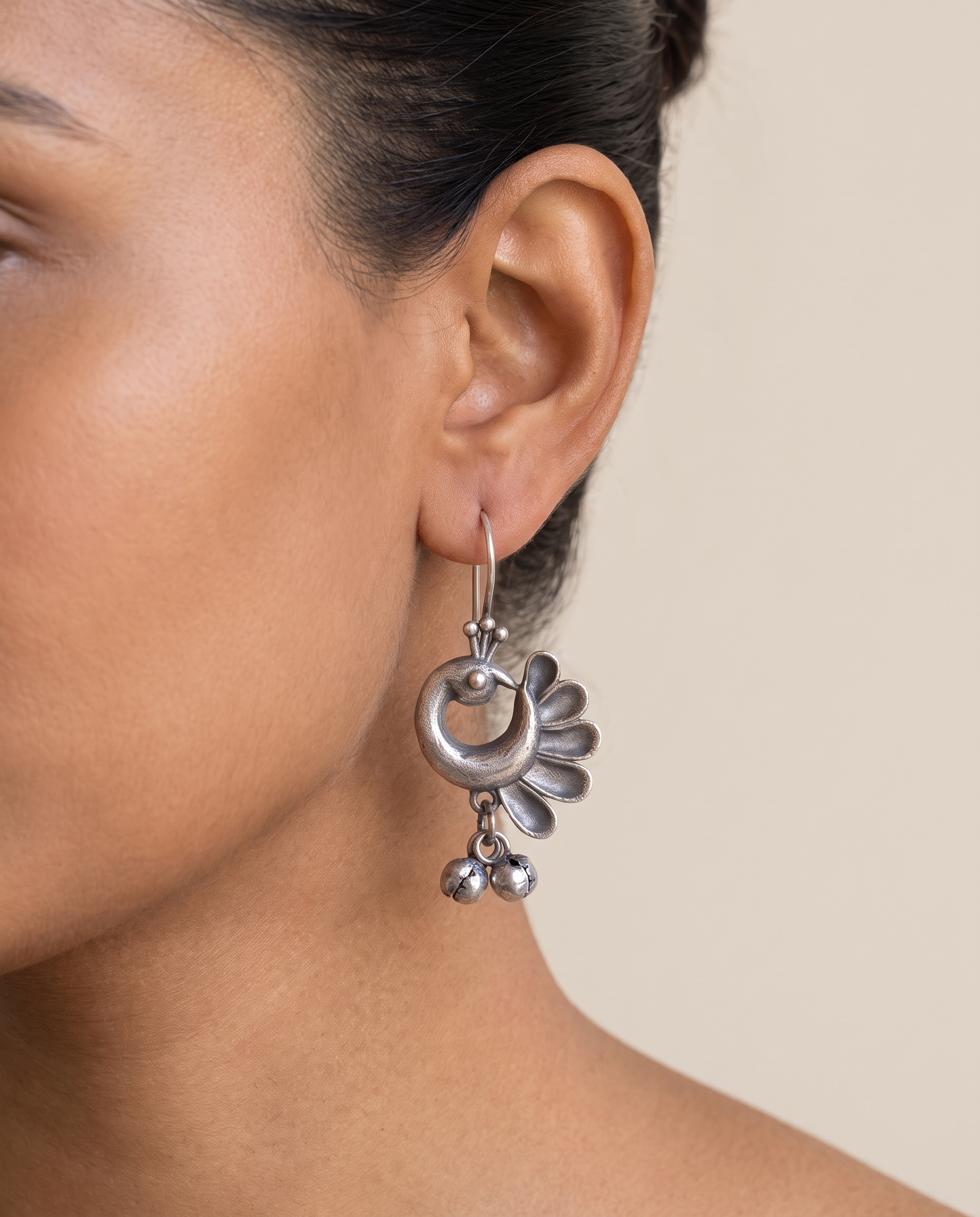 Chandrika crescent peacock earring worn on the earlobe