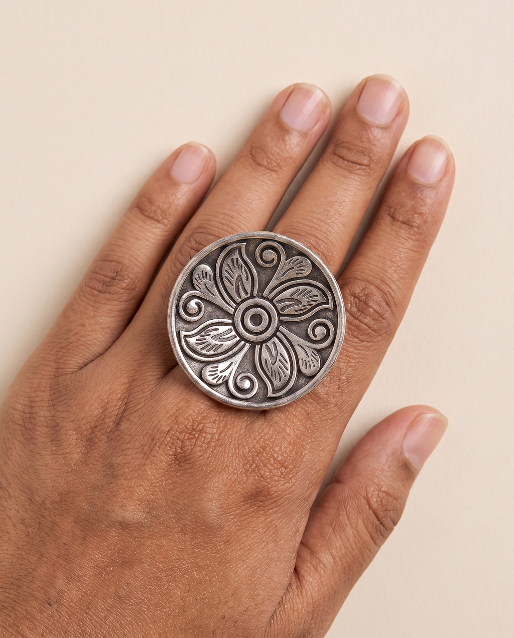Ranchi engraved floral disc ring worn on the middle finger