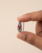 Zari teardrop nose pin held between fingertips in profile, showing its small size and its fitting
