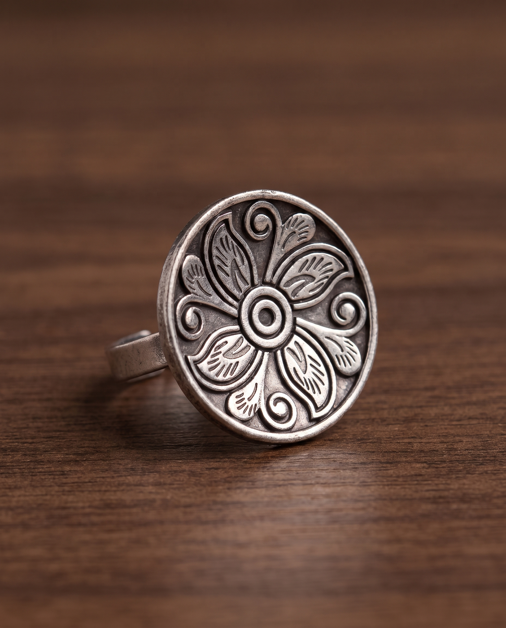 Close-up of the Ranchi engraved disc ring on walnut wood showing the depth of the engraving