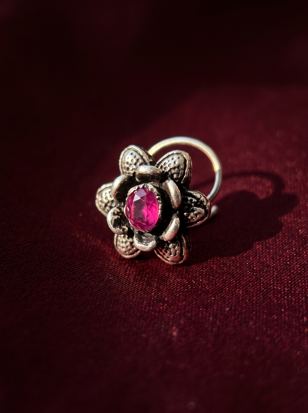 Urban Tevar Divi floral oxidised silver nose pin with purple stone, oxblood backdrop