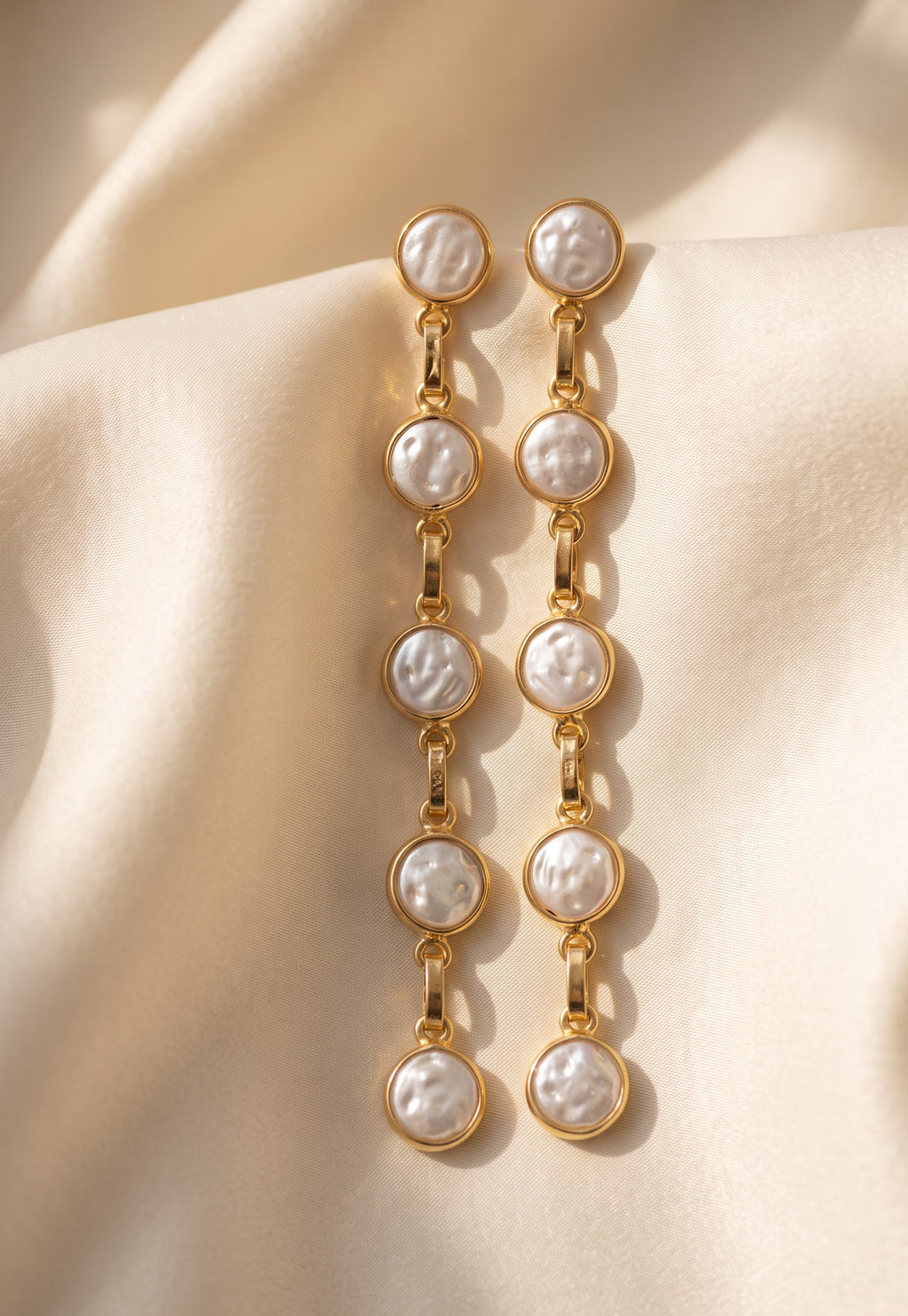 Five-pearl row drop earrings on a light background