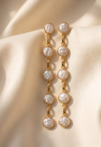 Five-pearl row drop earrings on a light background