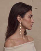 Five-pearl row drop earrings worn on a model