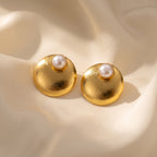 Gold-tone freshwater pearl dome stud earrings on cream silk