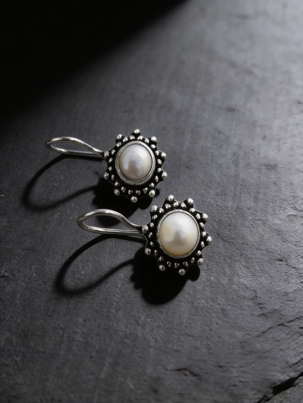 Freshwater pearl drop earrings on a dark background