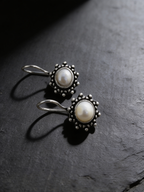 Freshwater pearl drop earrings on a dark background