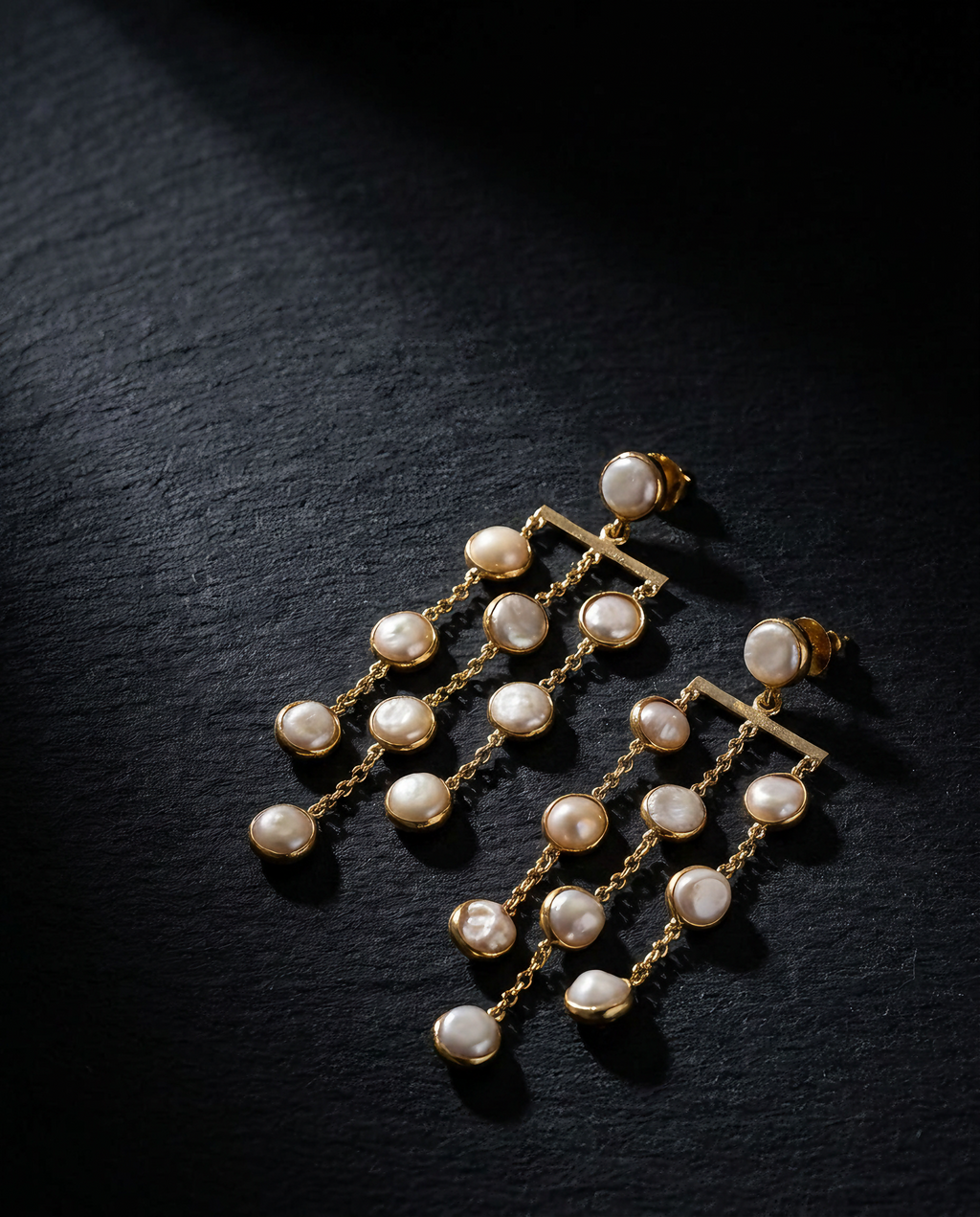 Freshwater pearl waterfall drop earrings on a dark background