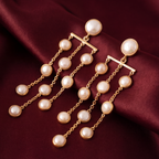 Long gold-tone anti-tarnish brass earrings with cascading strands of freshwater pearls, styled on burgundy silk