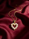 Gold-tone anti-tarnish brass necklace with a small pearl heart pendant, styled on burgundy silk