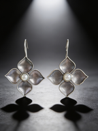 Silver-tone pearl petal drop earrings on a graphite studio backdrop