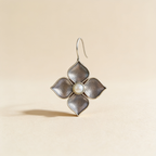 Silver-tone pearl petal drop earrings on a light background