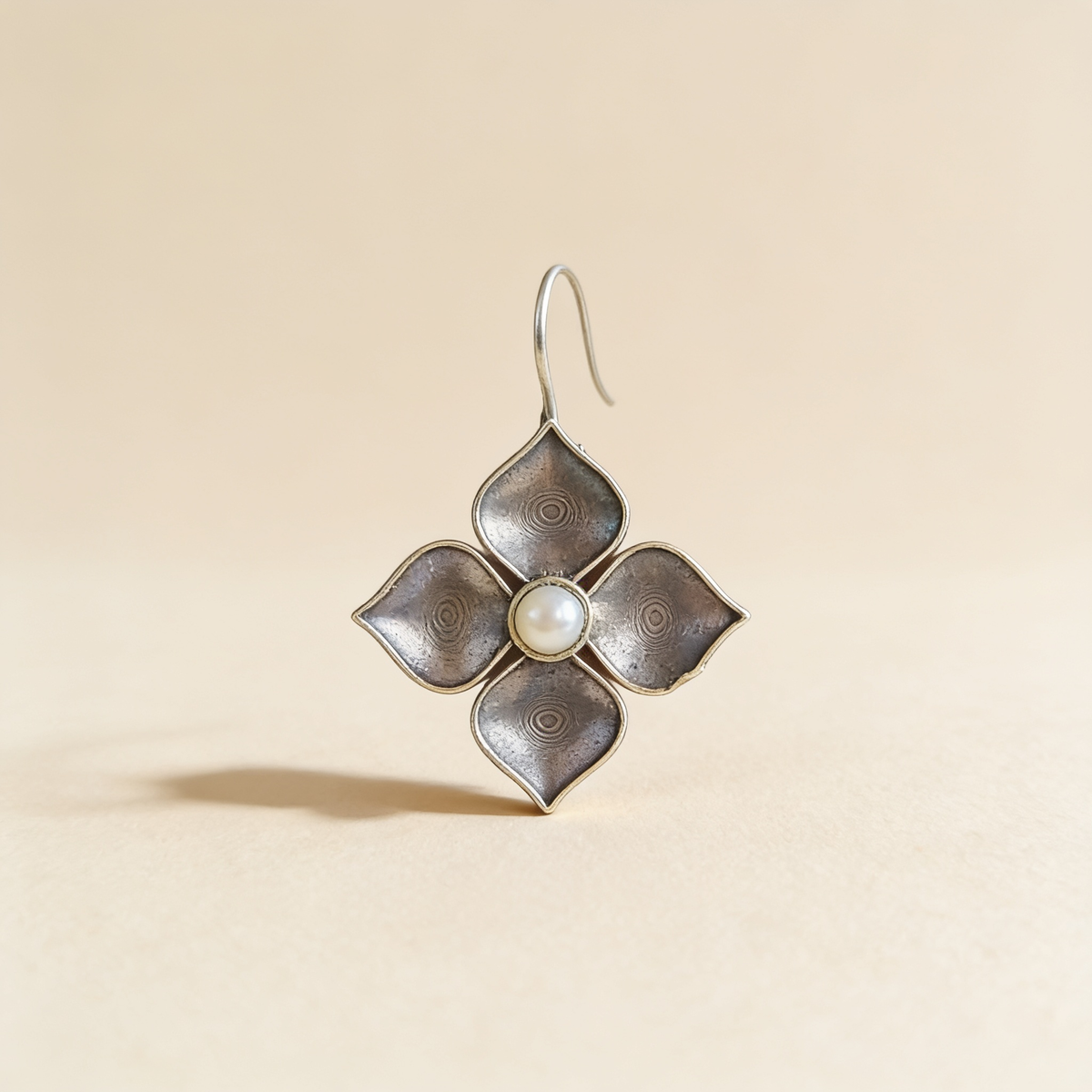 Silver-tone pearl petal drop earrings on a light background