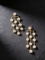 Pearl waterfall drop earrings on a dark background
