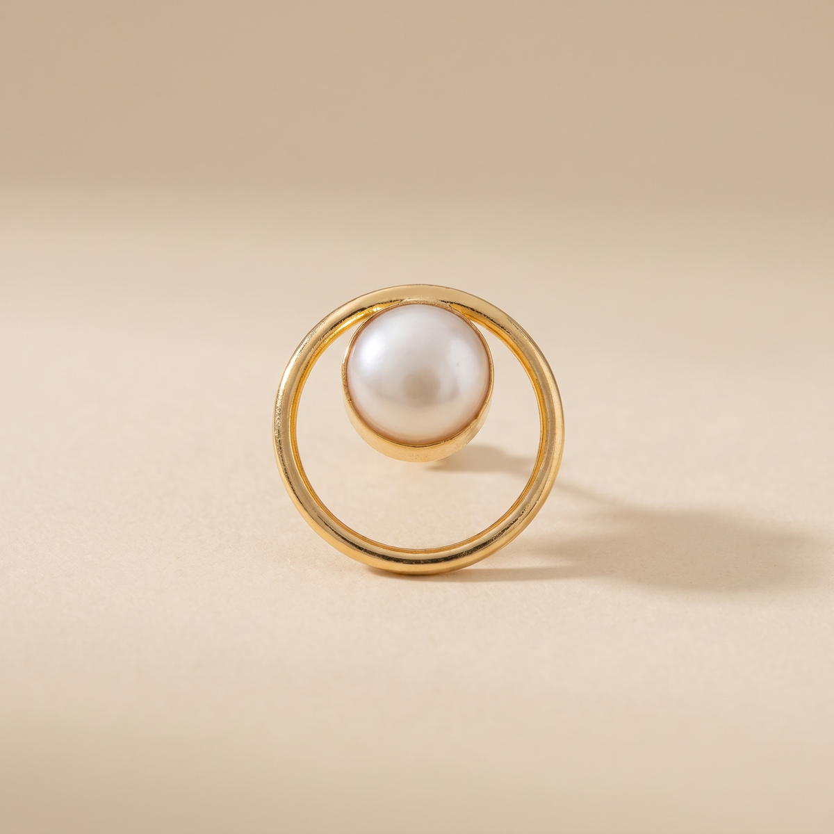 Round frame pearl stud earrings on a light background