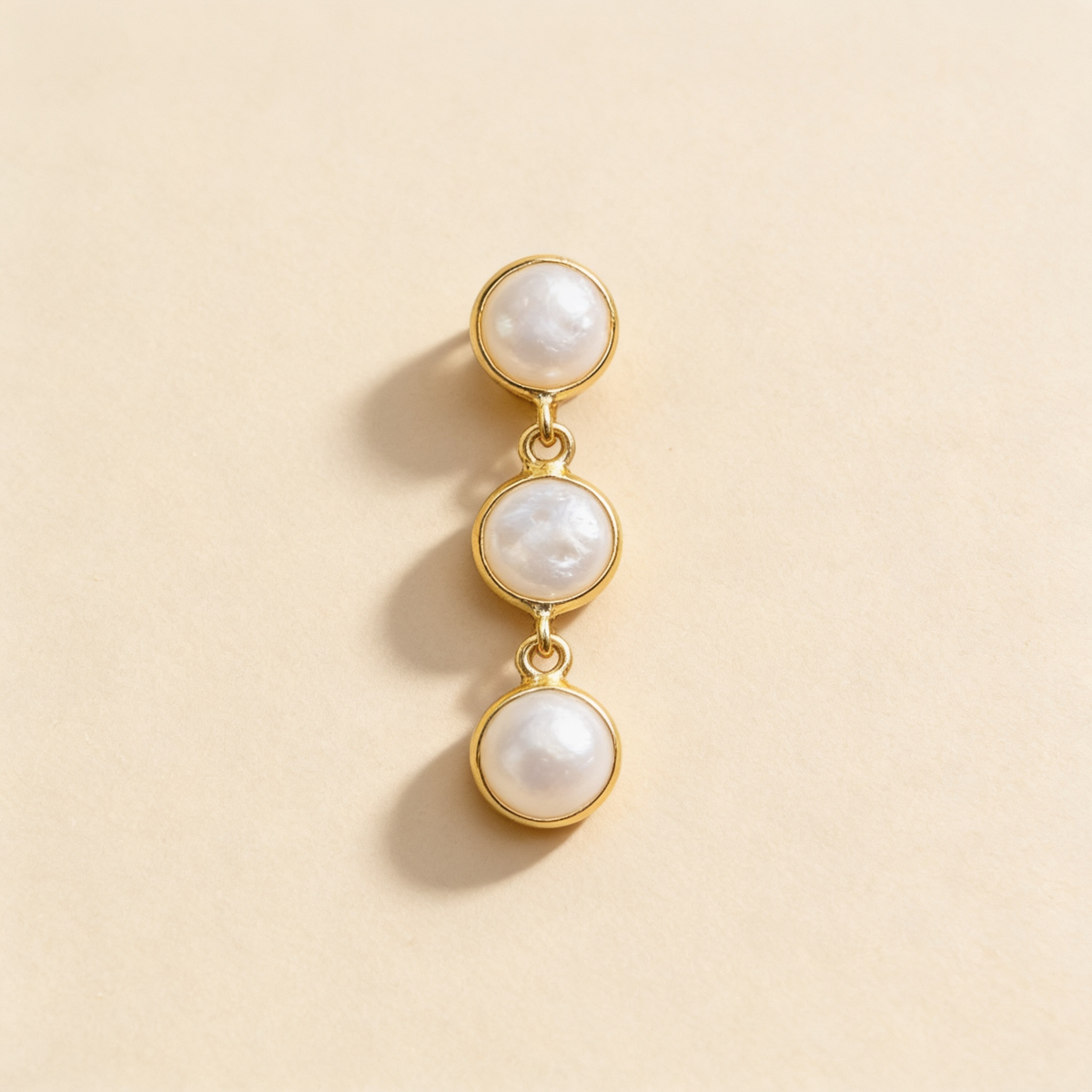 Trio pearl stud earrings on a light background