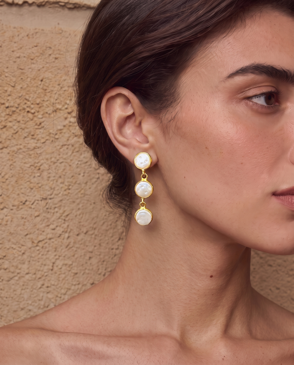 Trio pearl stud earrings worn on a model