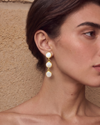 Trio pearl stud earrings worn on a model