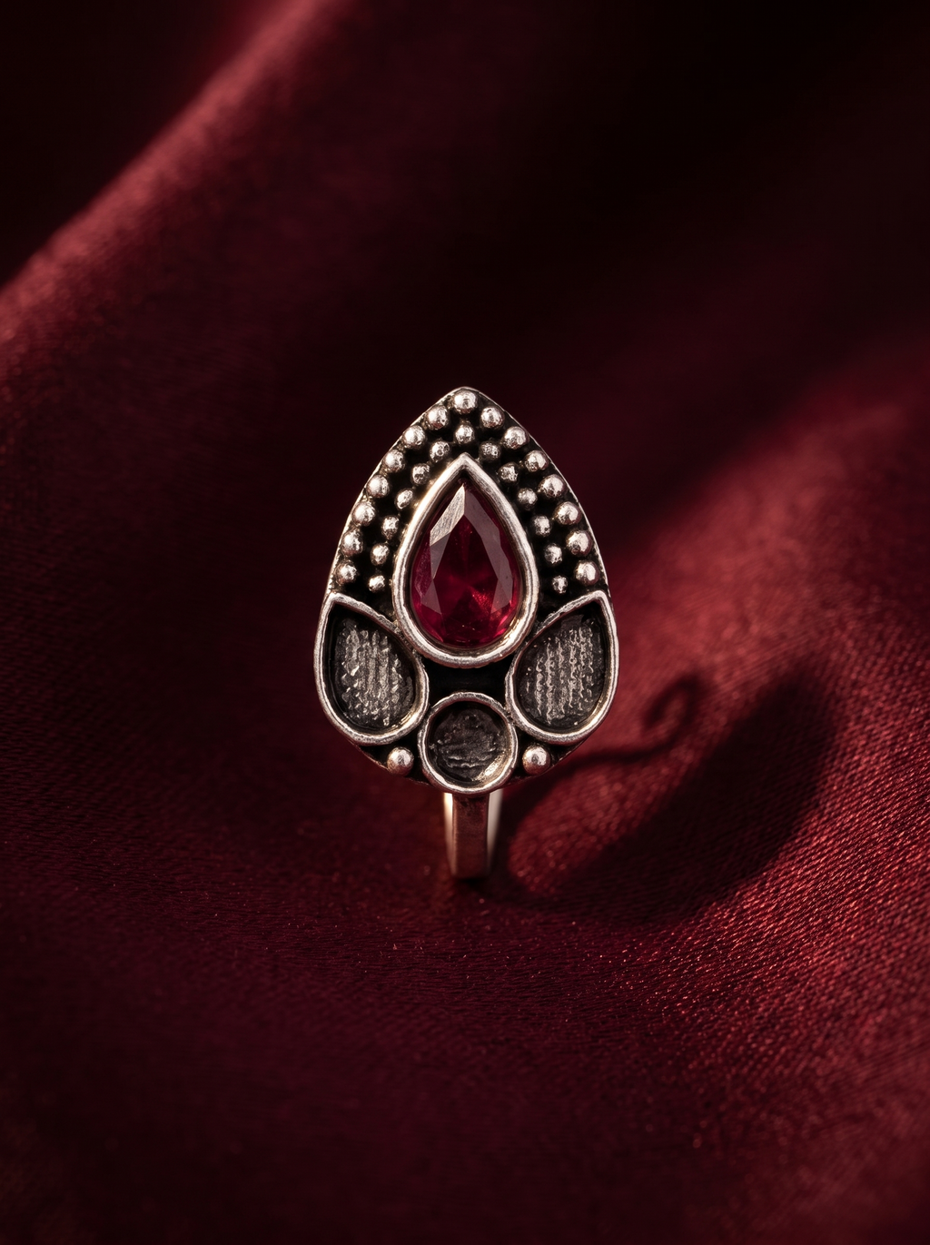 Urban Tevar Zari teardrop oxidised silver clip-on nose pin with red stone, oxblood backdrop